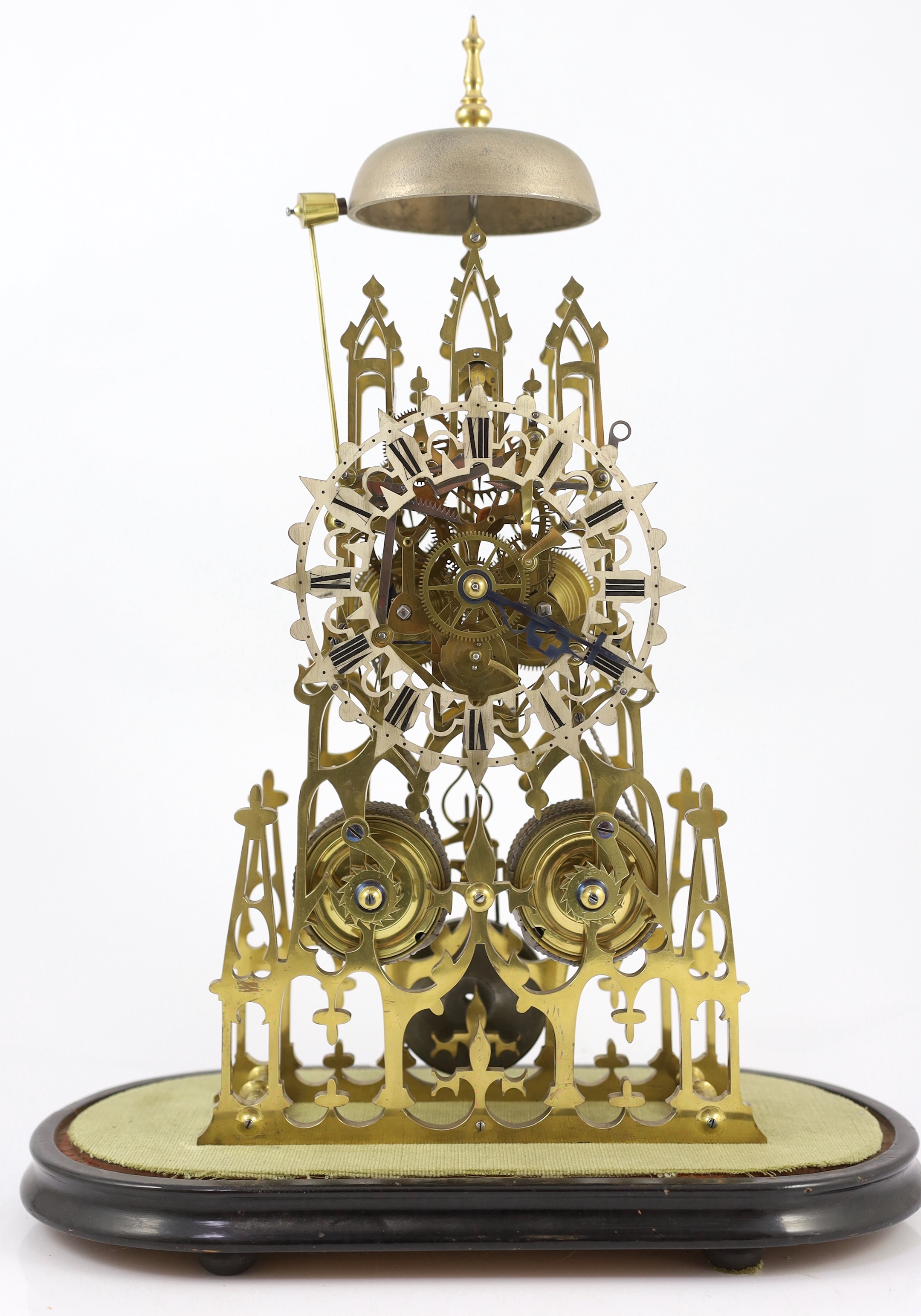 A Victorian brass cathedral skeleton clock, 46cm high, with ebonised stand and glass dome, overall 52cm high